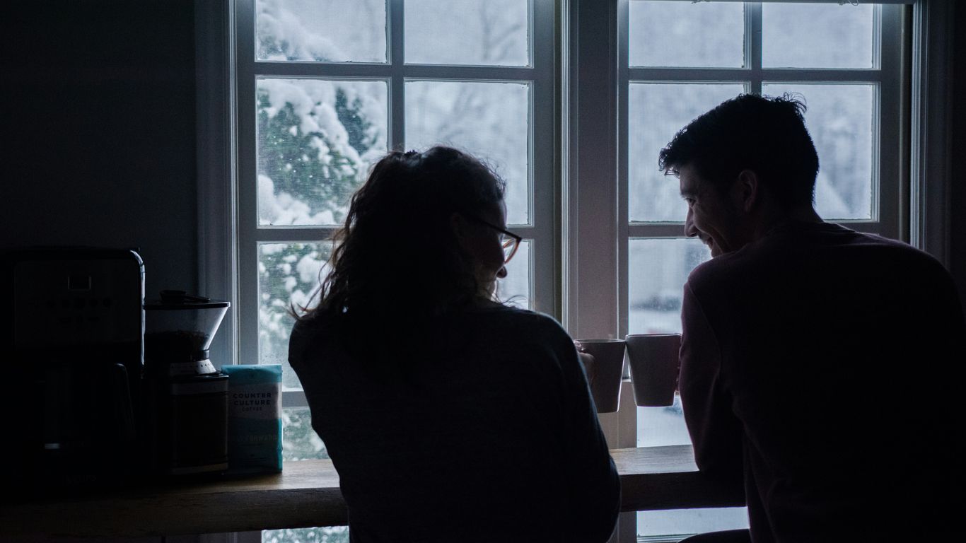 silhouette of man and woman sitting on bar stools