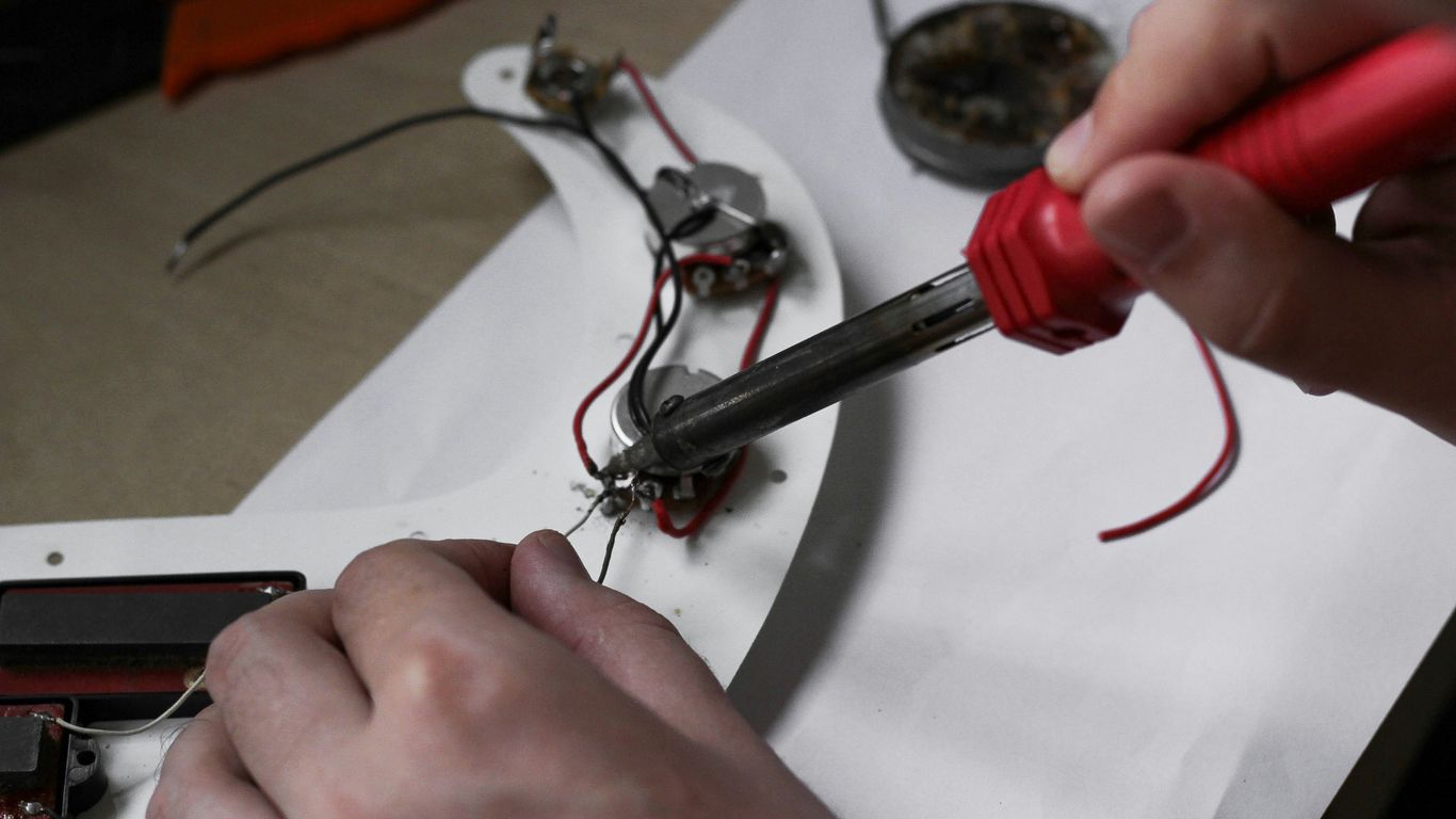 A person is working on some electrical equipment