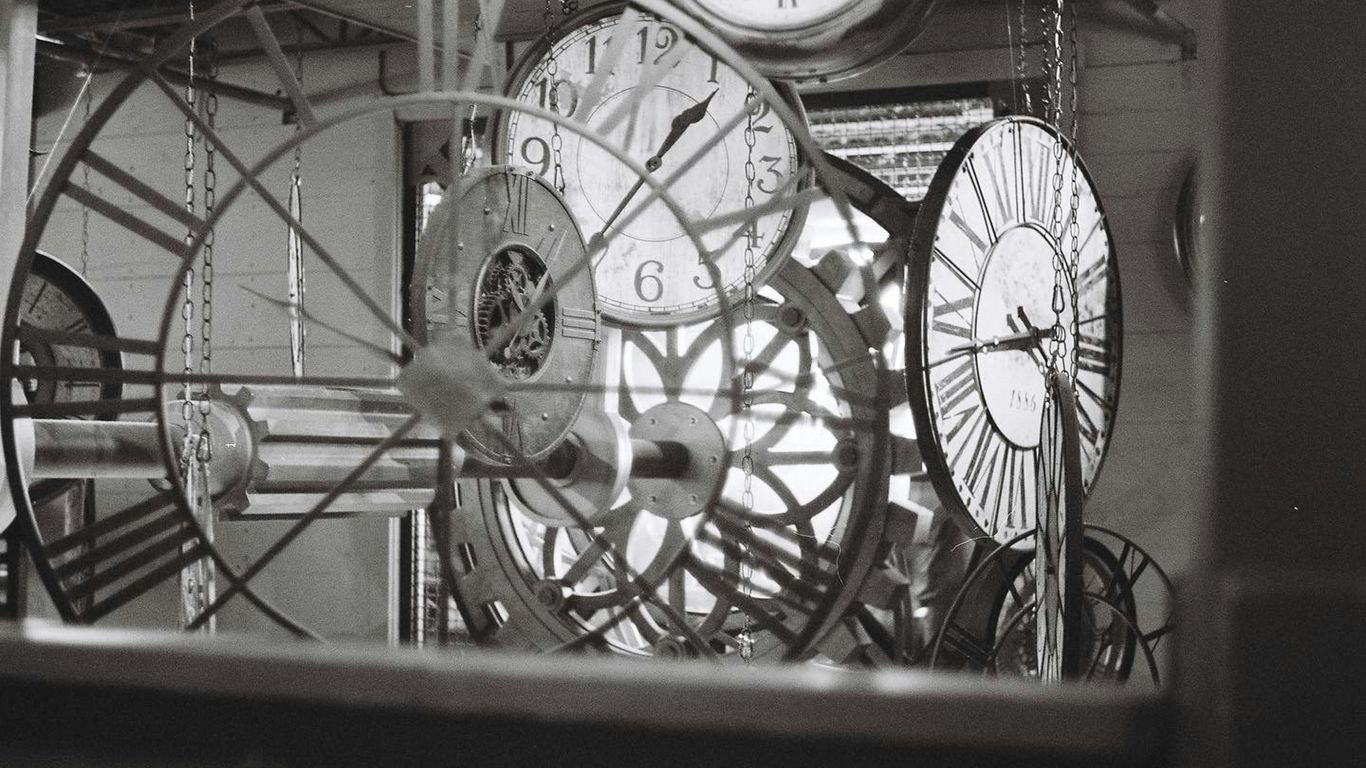 a bunch of clocks hanging from the ceiling