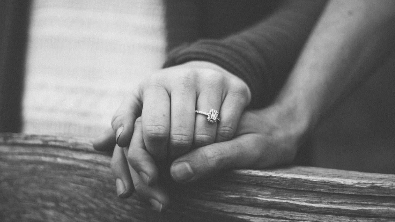 a couple holding hands with a wedding ring visible