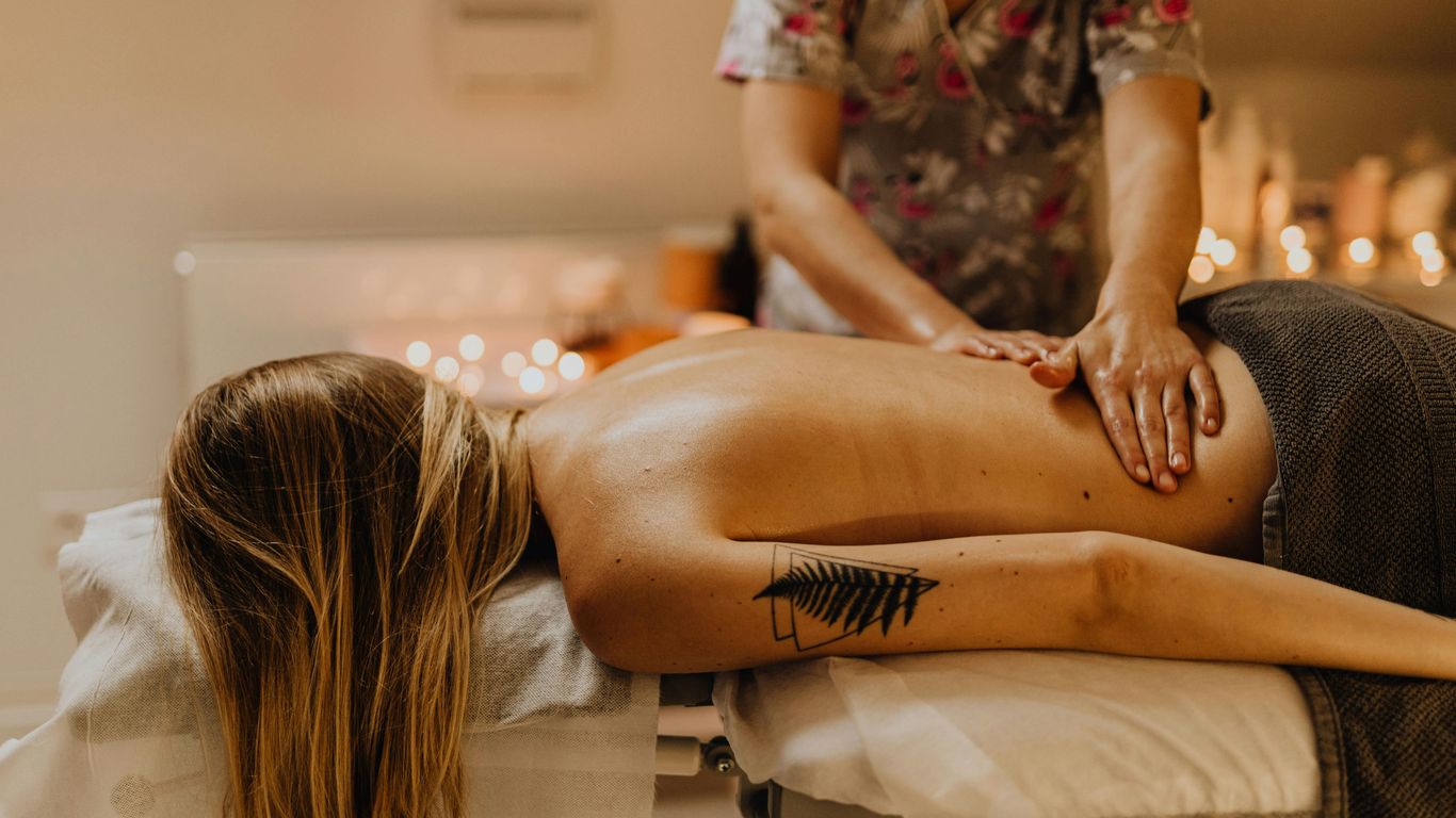 Person receiving a relaxing back massage in a cozy setting.