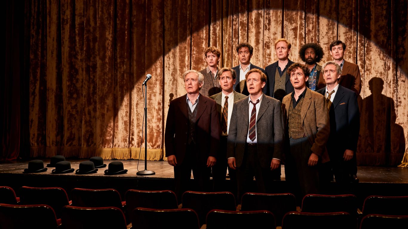 British comedians on stage with empty audience seats