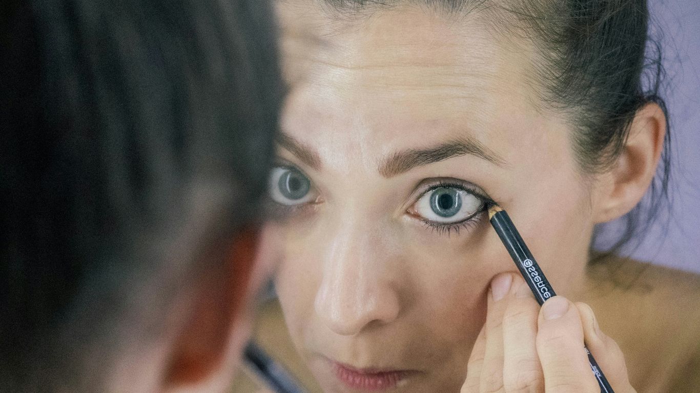 a woman is looking at her reflection in the mirror