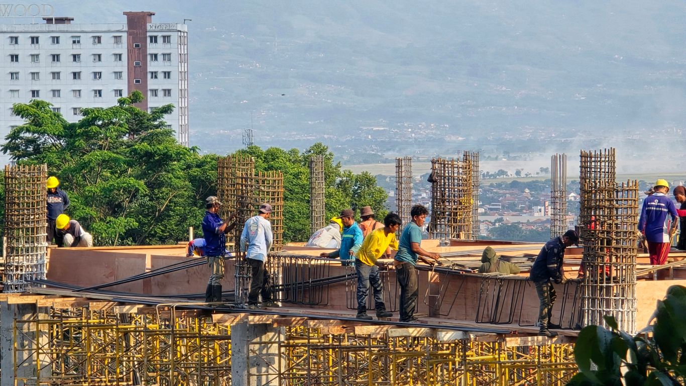 Workers are building a structure on a construction site.
