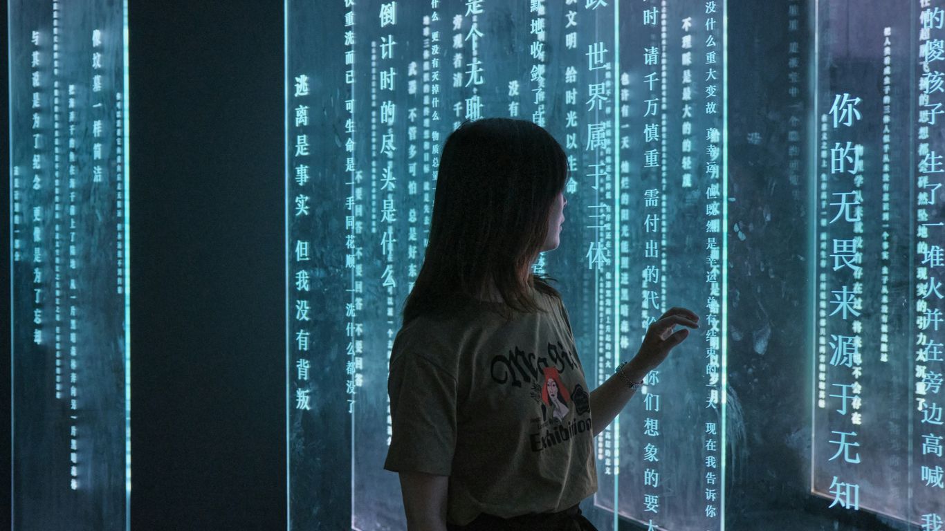 woman in gray crew neck t-shirt standing in front of blue and white string lights