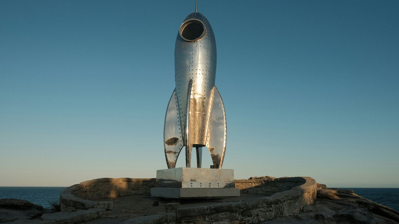 A statue of a rocket sitting on top of a rock