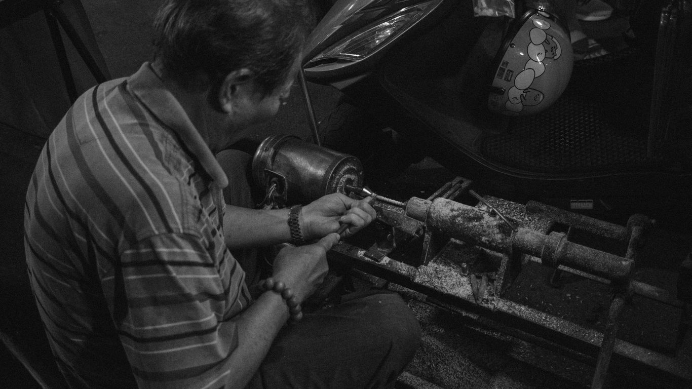 grayscale photograpy of man fixing equipment