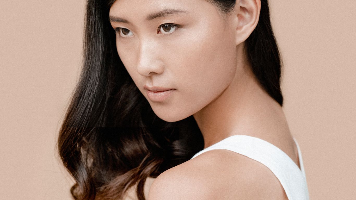 A person with long hair against a neutral background.