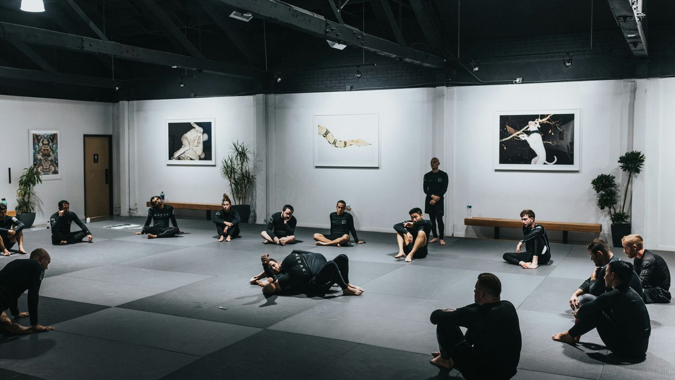 people sitting on floor in front of white wall