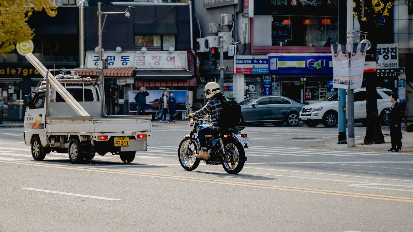 A motorcyclist rides down a city street.