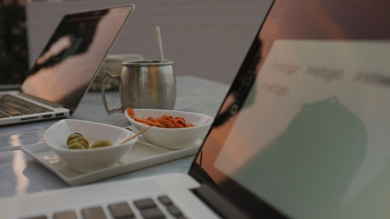 macbook pro beside black framed eyeglasses