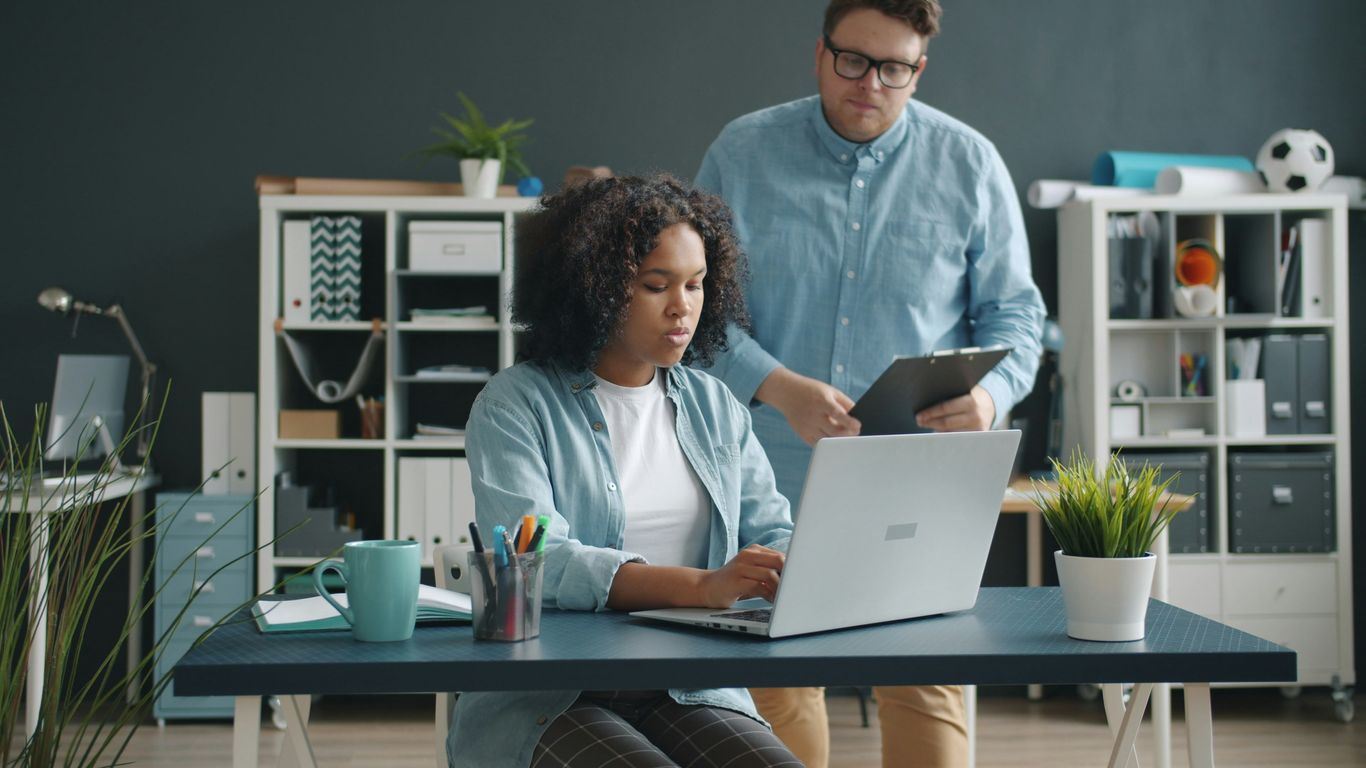 Two colleagues working together at a desk.