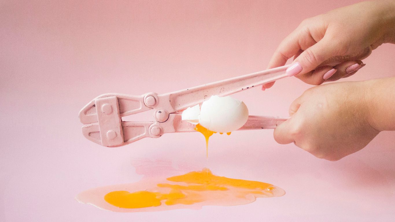 person holding white plastic spoon with yellow powder