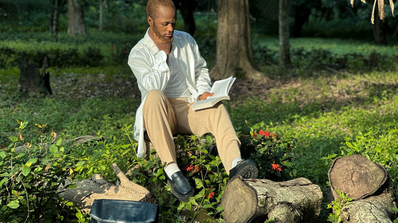 a man sitting on top of a pile of logs