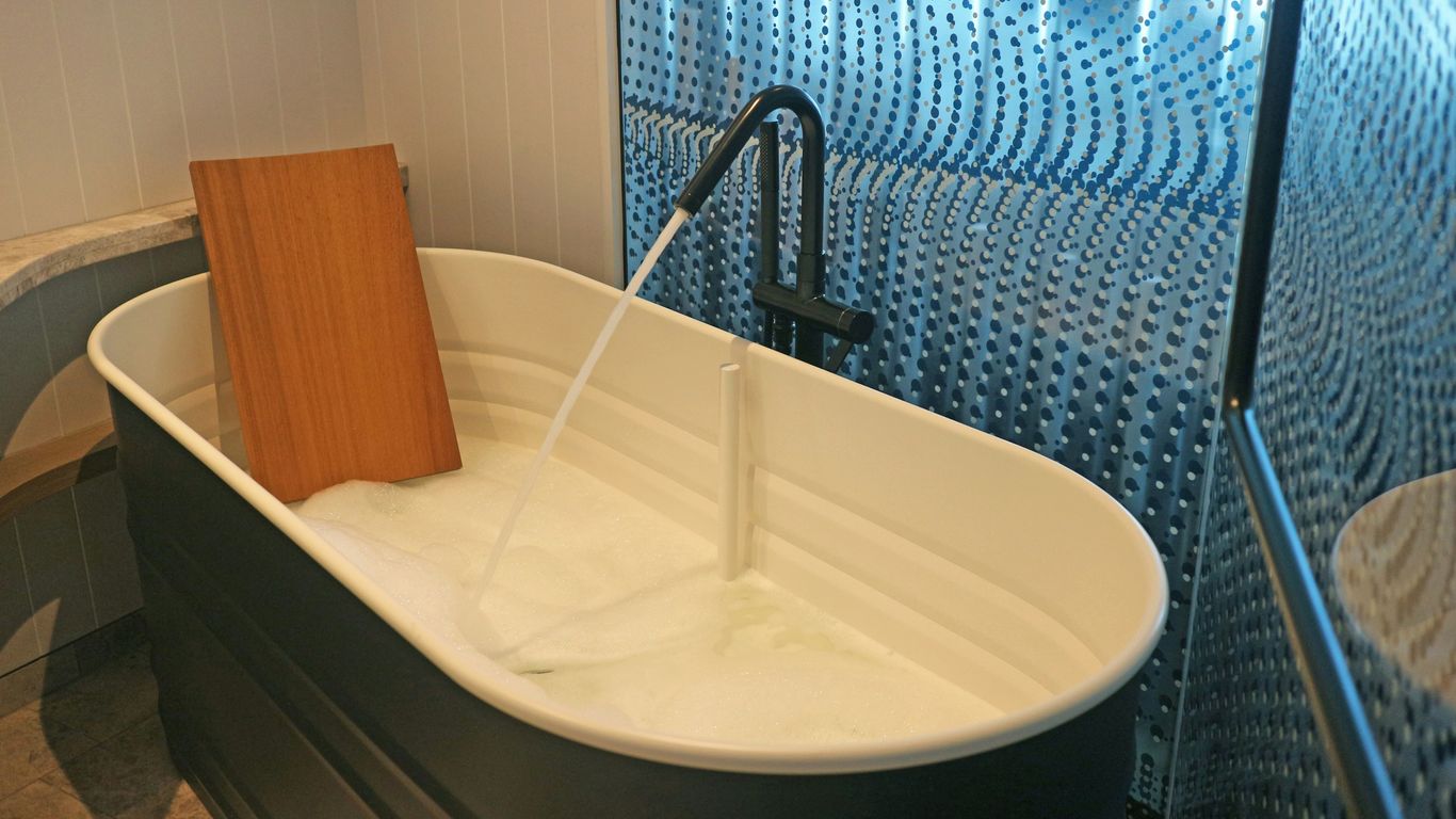 a white bath tub sitting next to a walk in shower