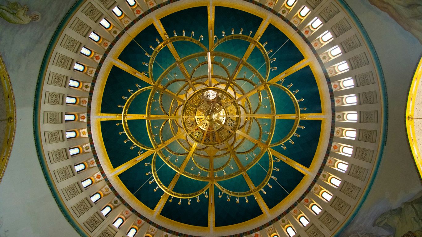 the ceiling of a building with a clock in the center