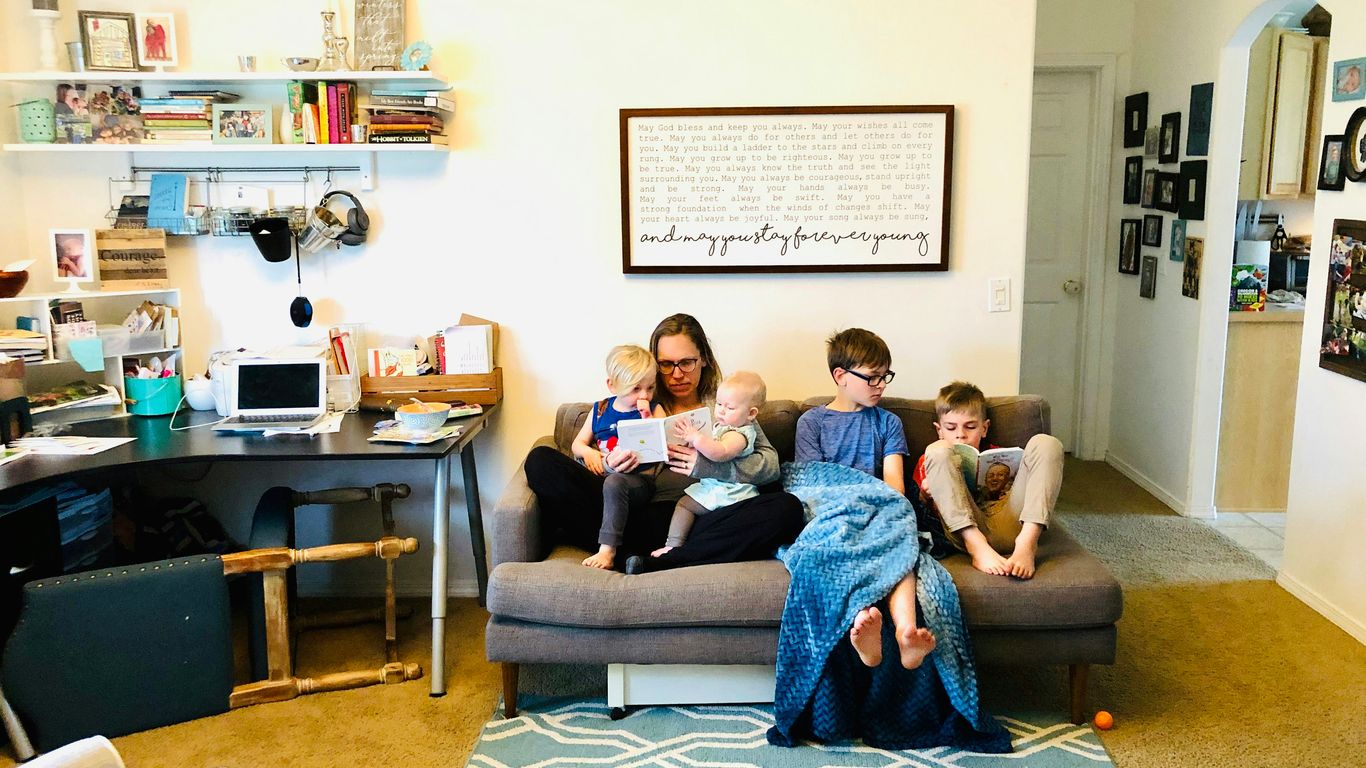 2 women and man sitting on gray sofa