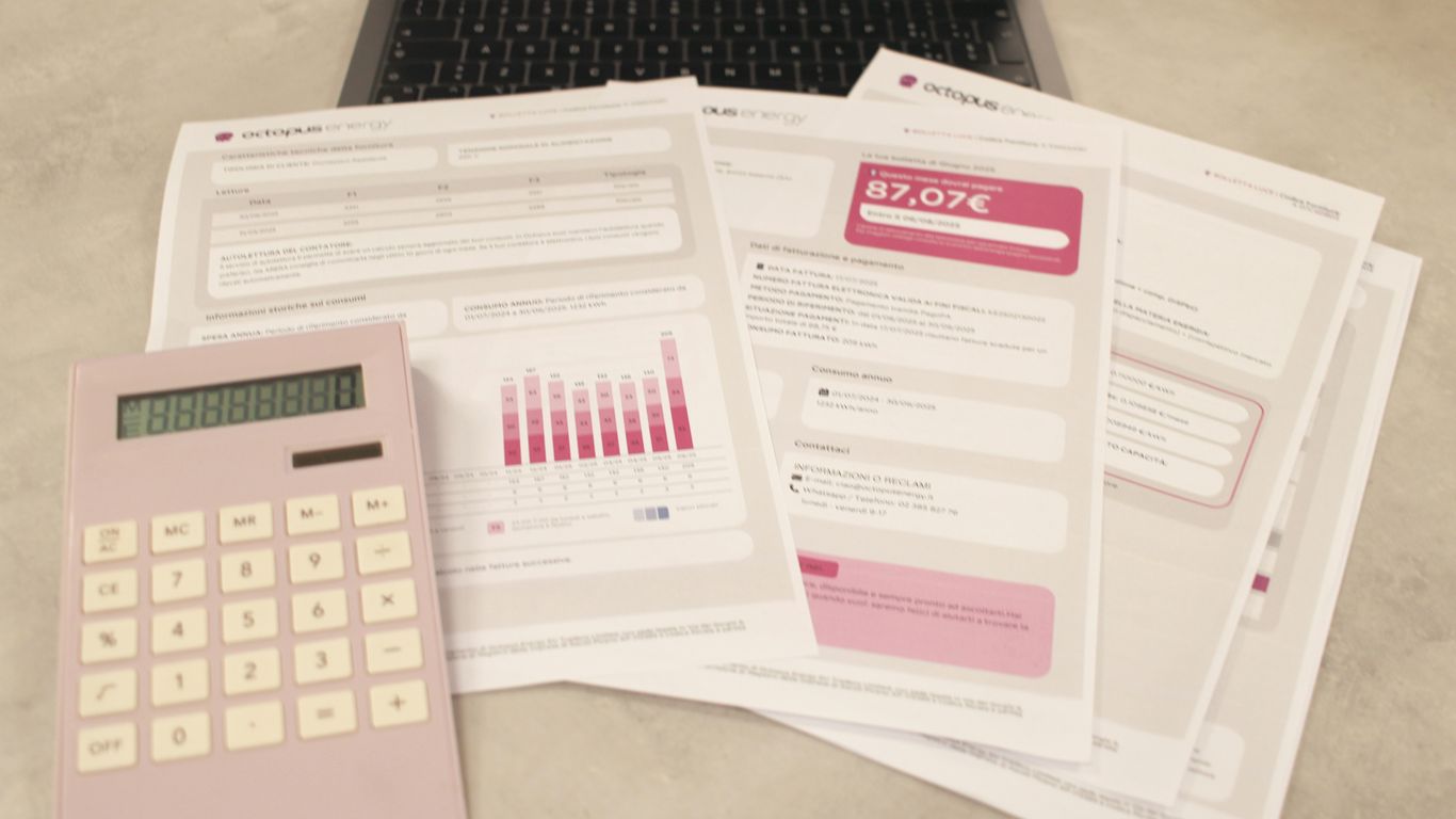 Bills, calculator, and a laptop: financial tasks underway.