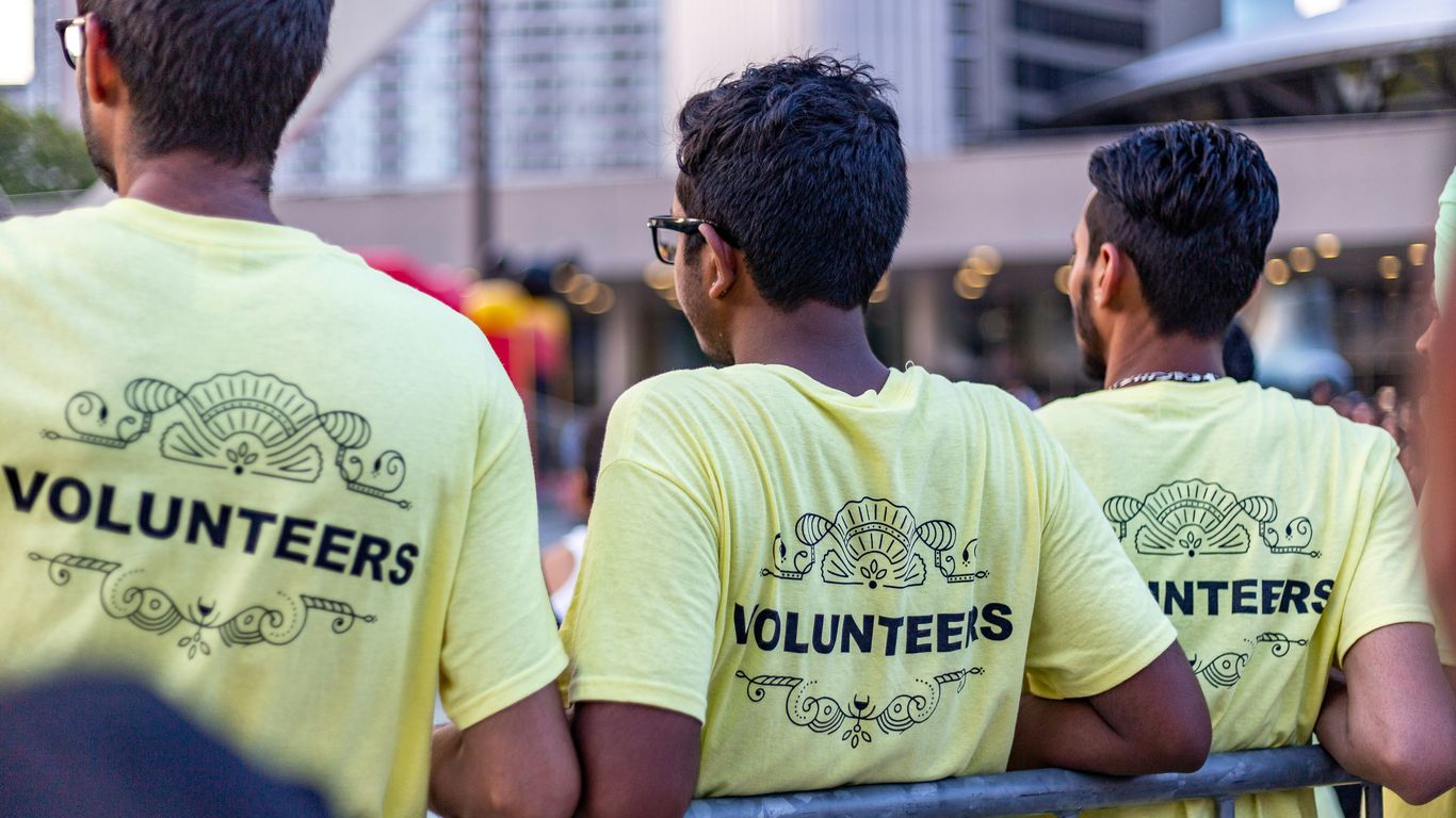 three men wearing yellow Volunteers shirts