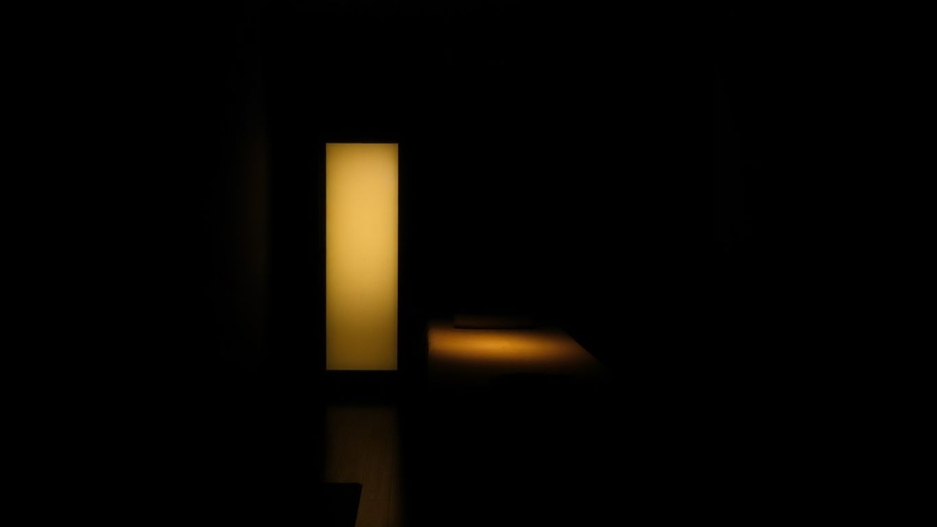 Intérieur sombre d'un salon de massage avec une table éclairée.