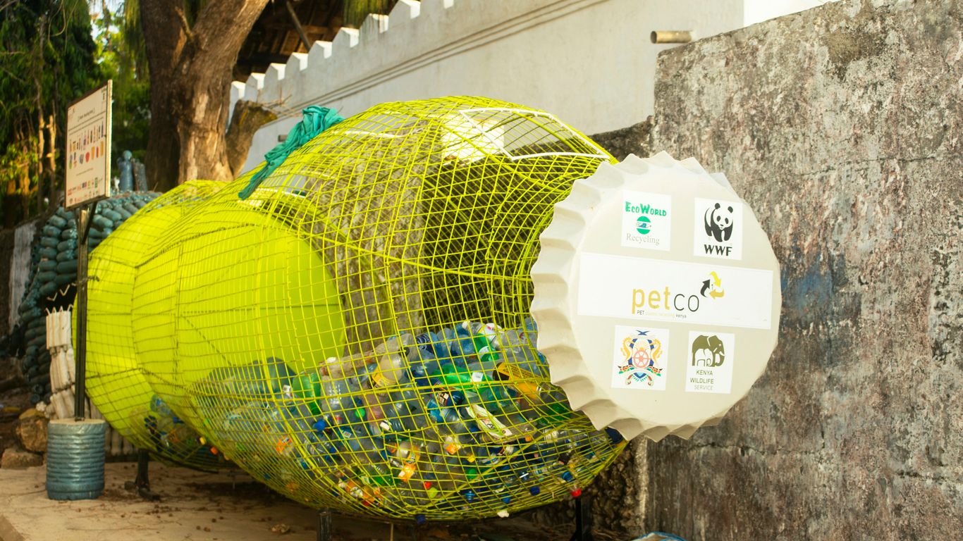 a yellow bird cage sitting on the side of a building