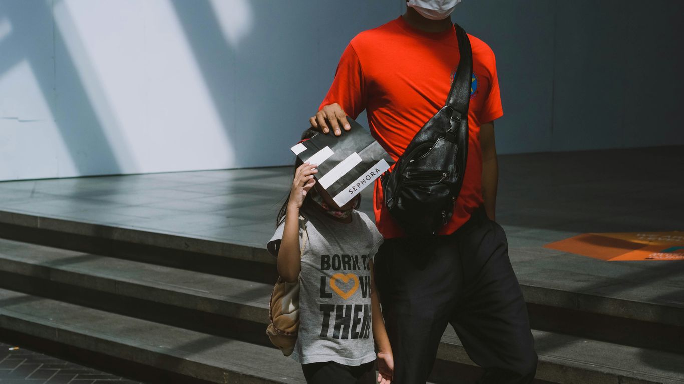 man in red crew neck t-shirt and black pants holding white and black labeled pack