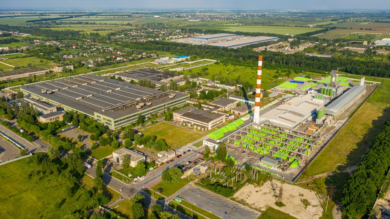 orange and white tower surrounded by green trees and buildings