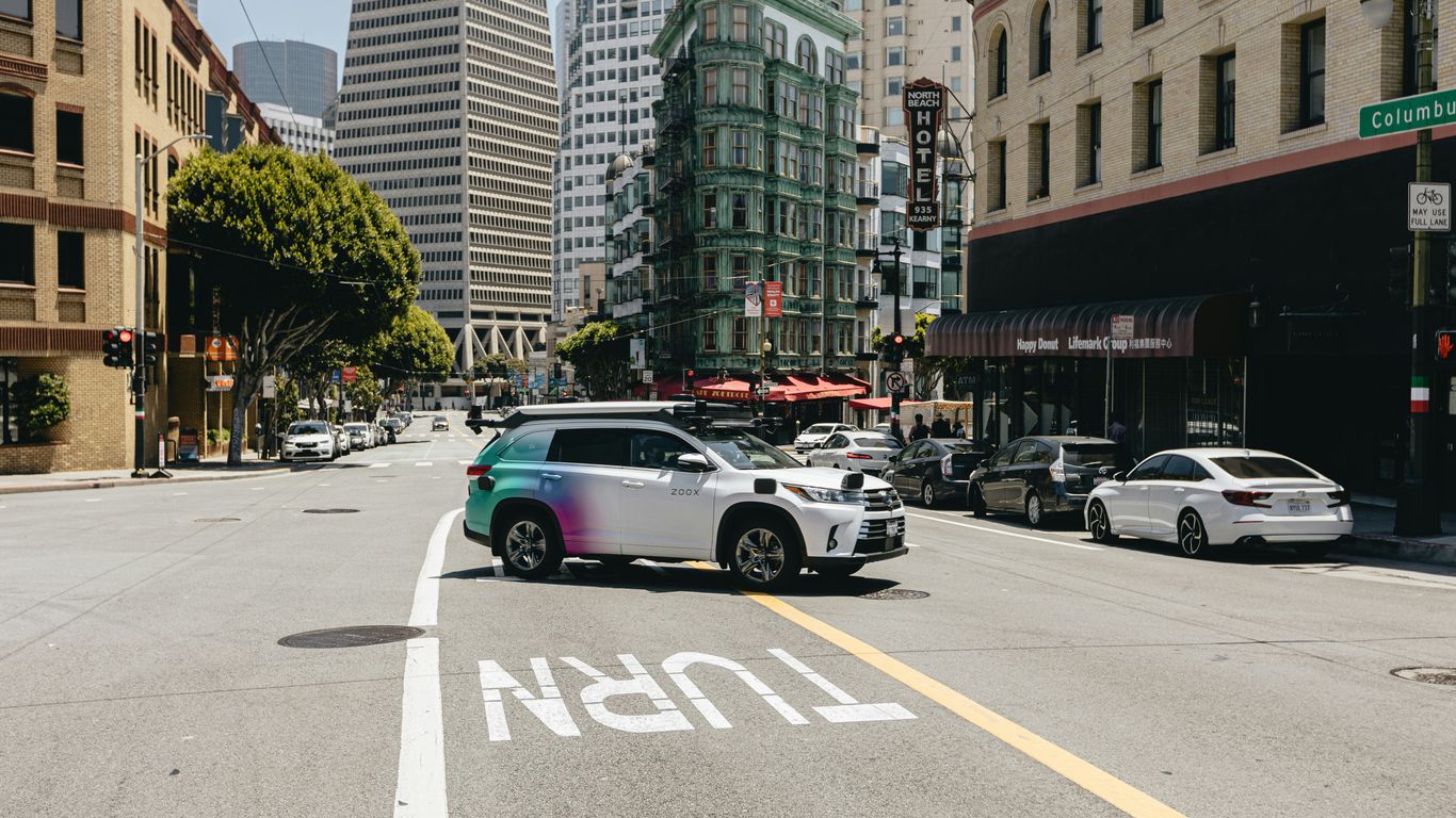 a car driving down a street next to tall buildings
