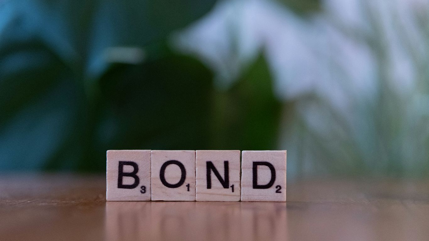 The word bond spelled with scrabble blocks on a table