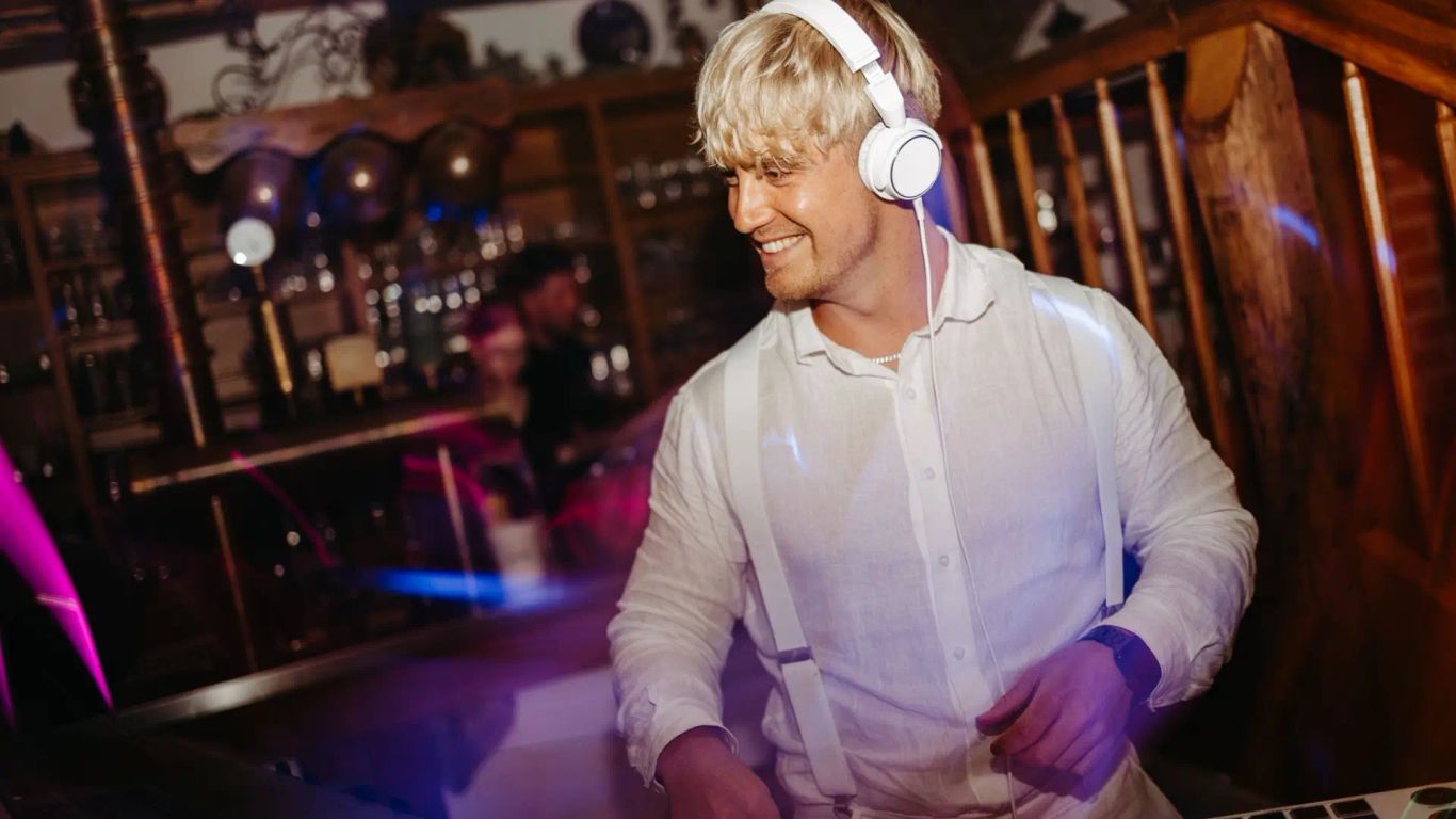 Hochzeits DJ Stuttgart Nathan White in ikonischem weißem Hemd und weißer Ausstattung in einer rusikalen Hochzeitslocation
