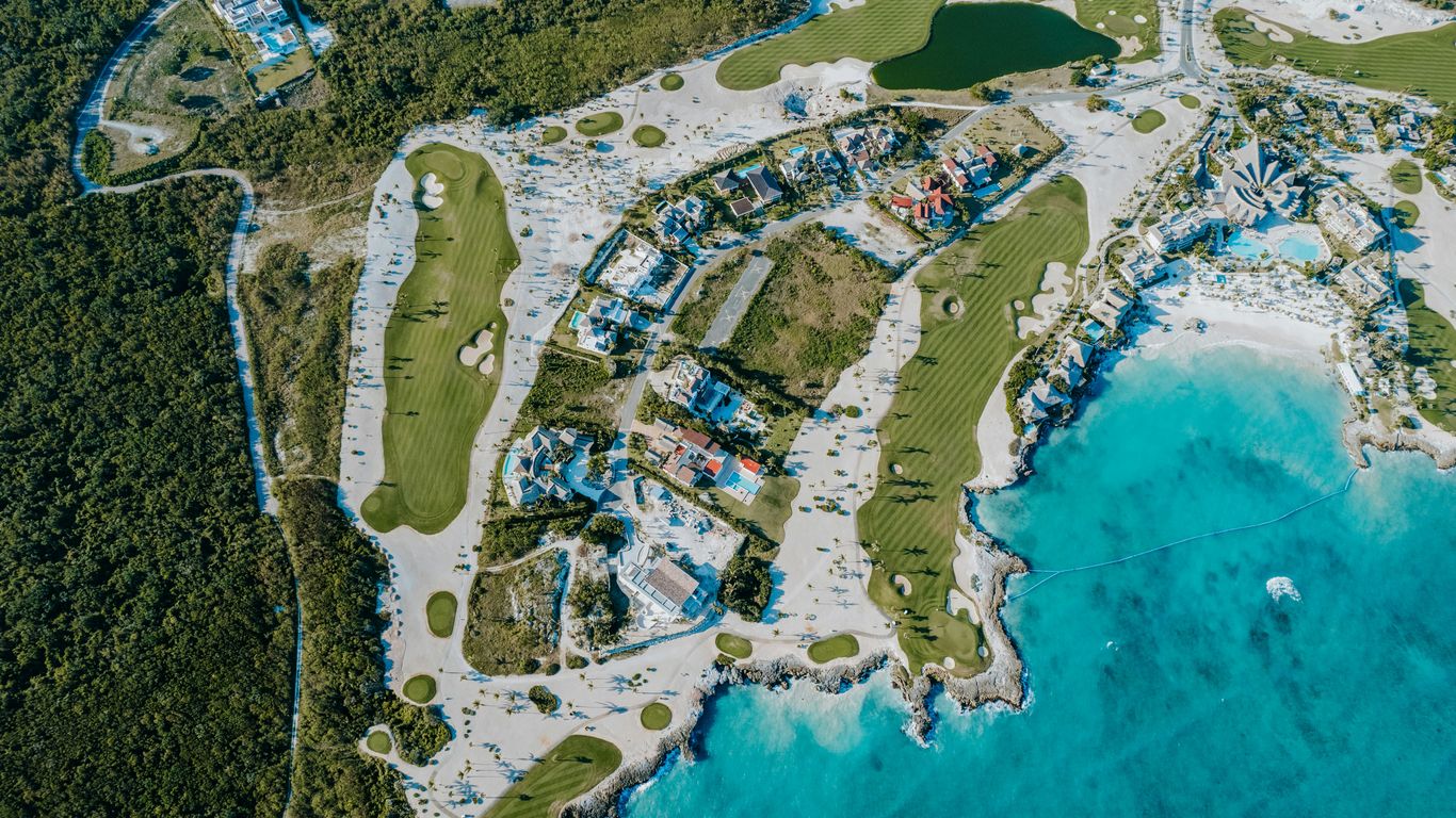 Aerial view of a golf course and beach resort.
