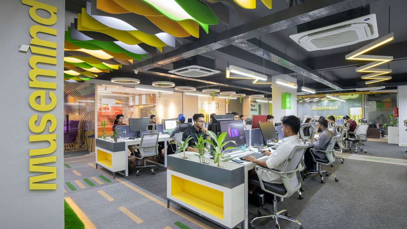 a group of people sitting at desks in an office