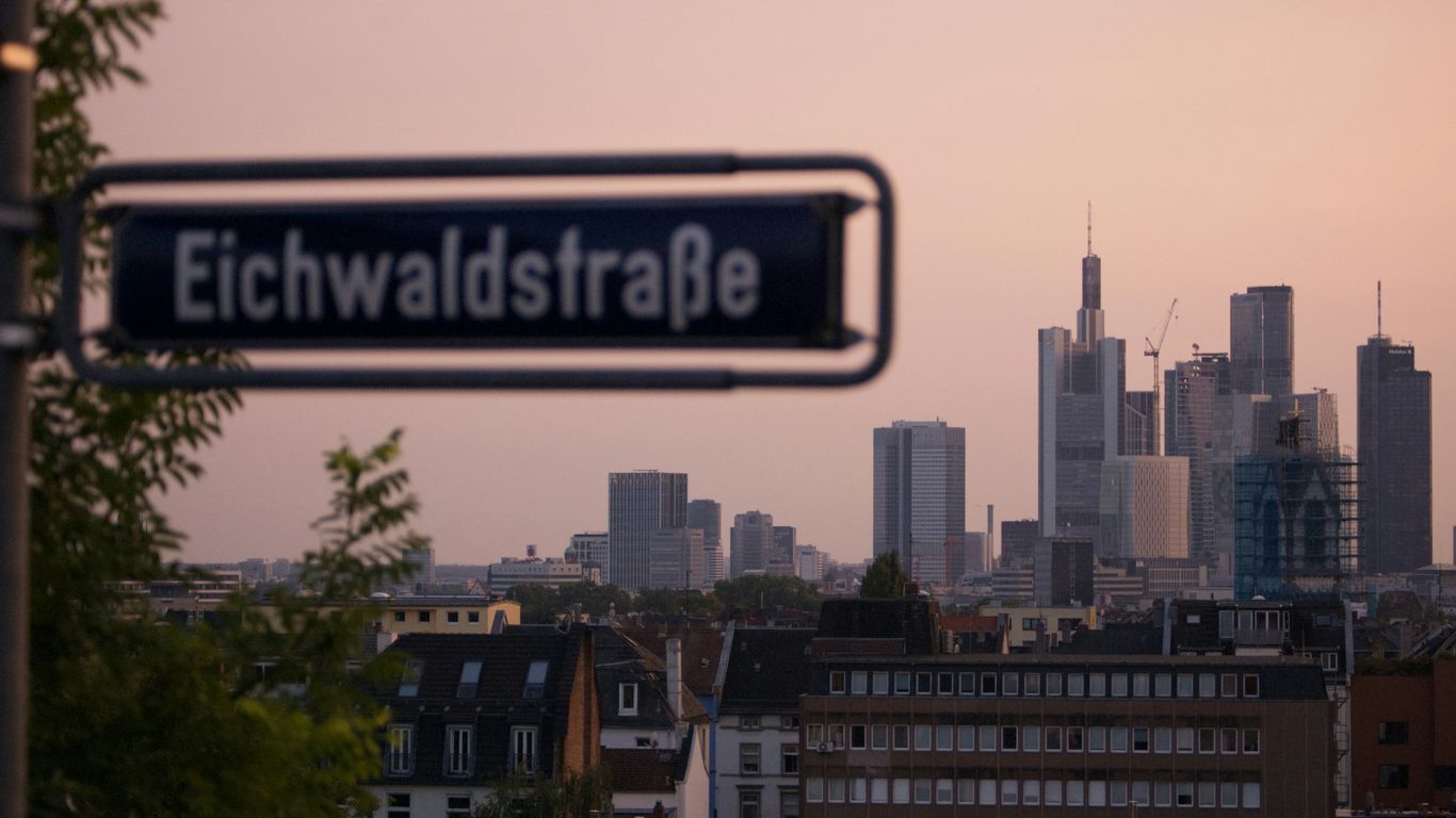 A street sign with a city in the background