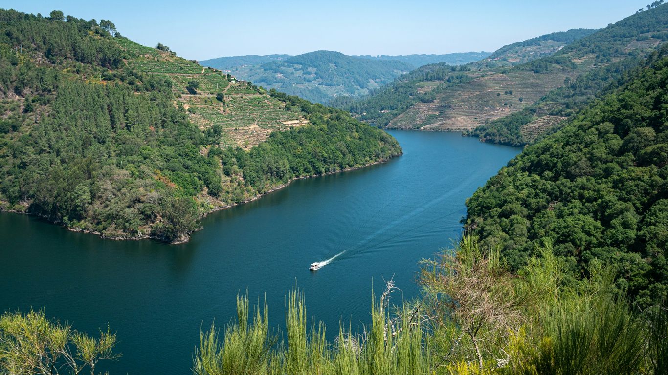 A large body of water surrounded by lush green hills