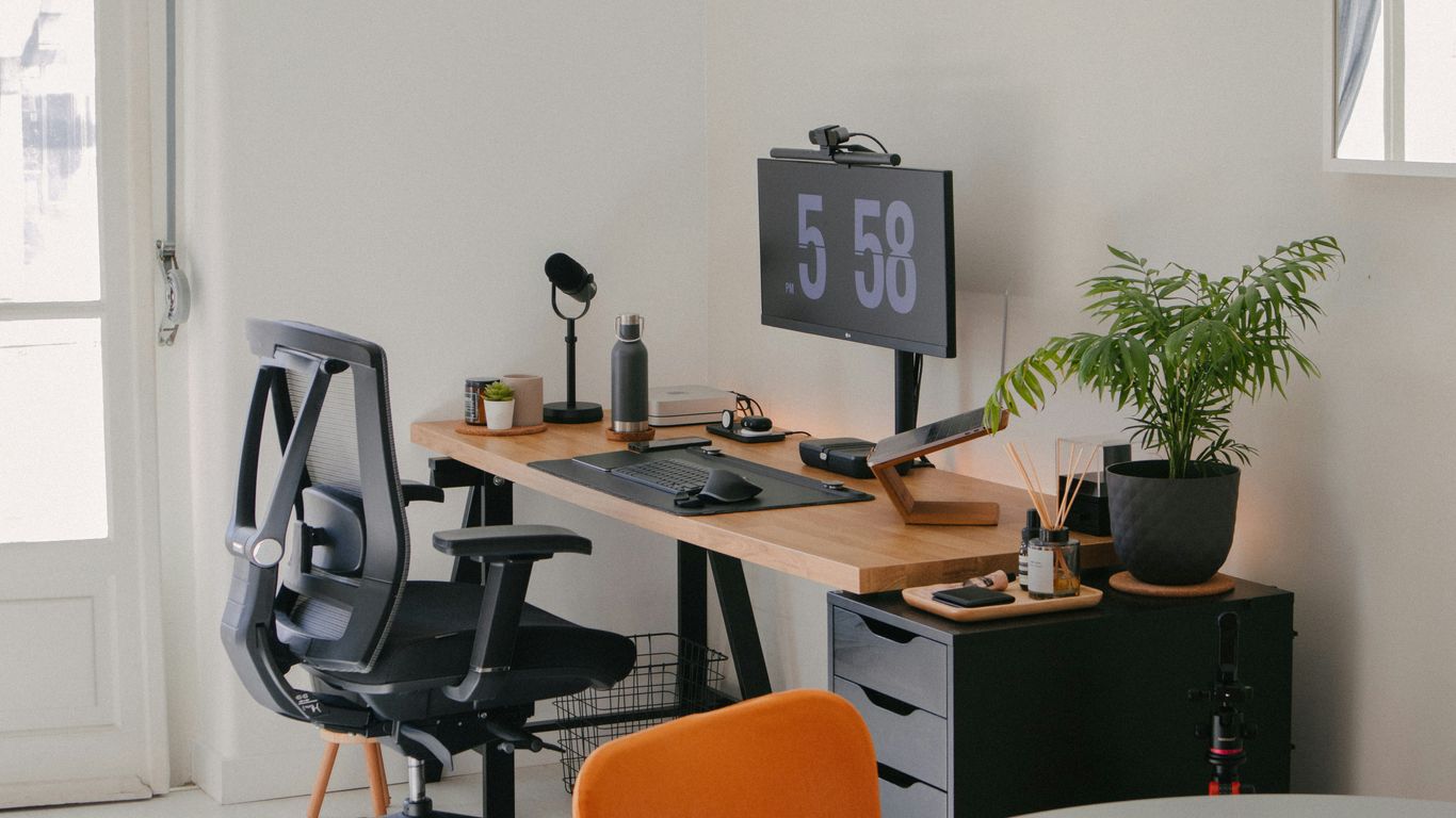 a desk with a computer and a chair in a room