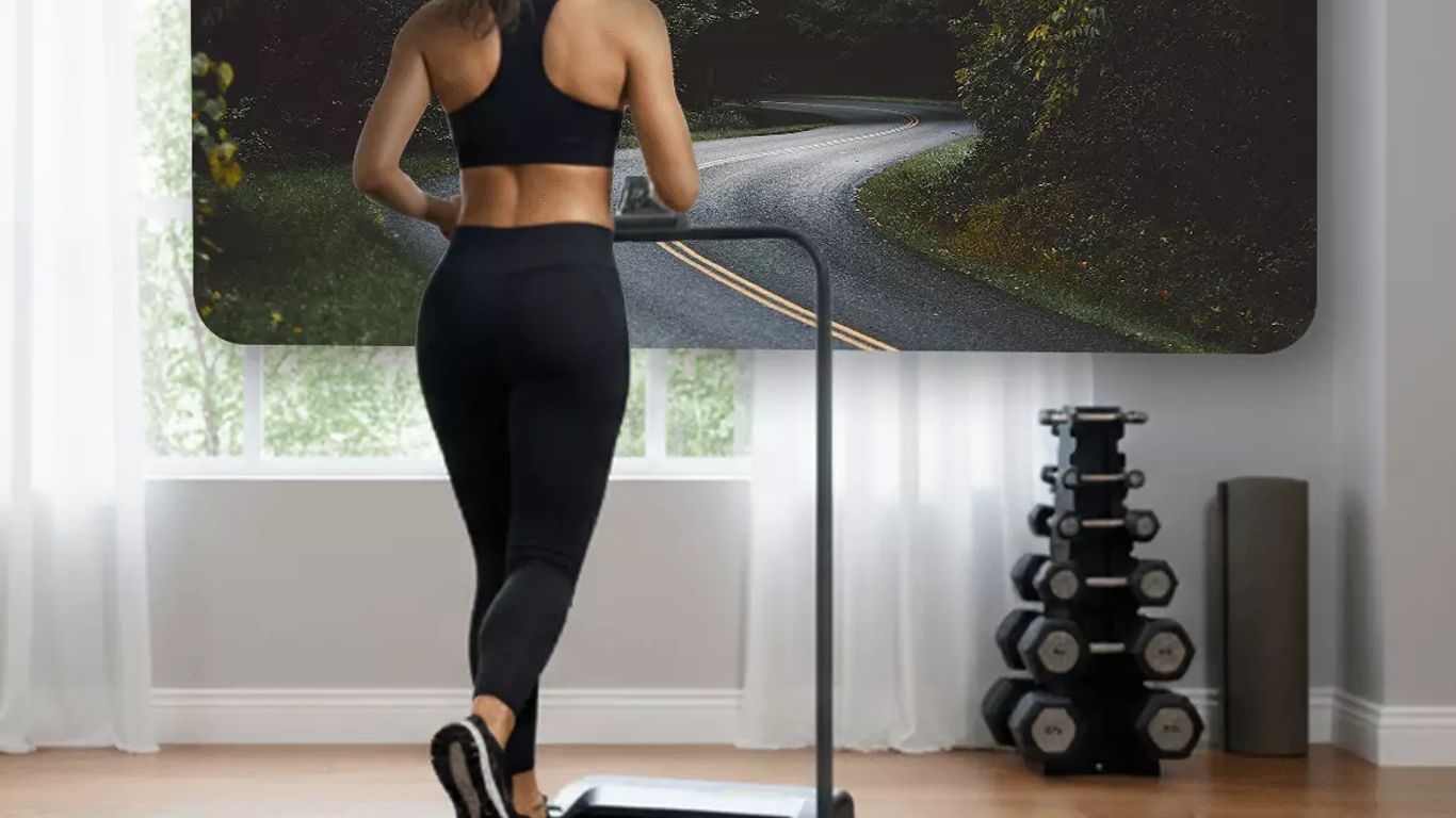 Person running on treadmill with scenic road displayed on screen.