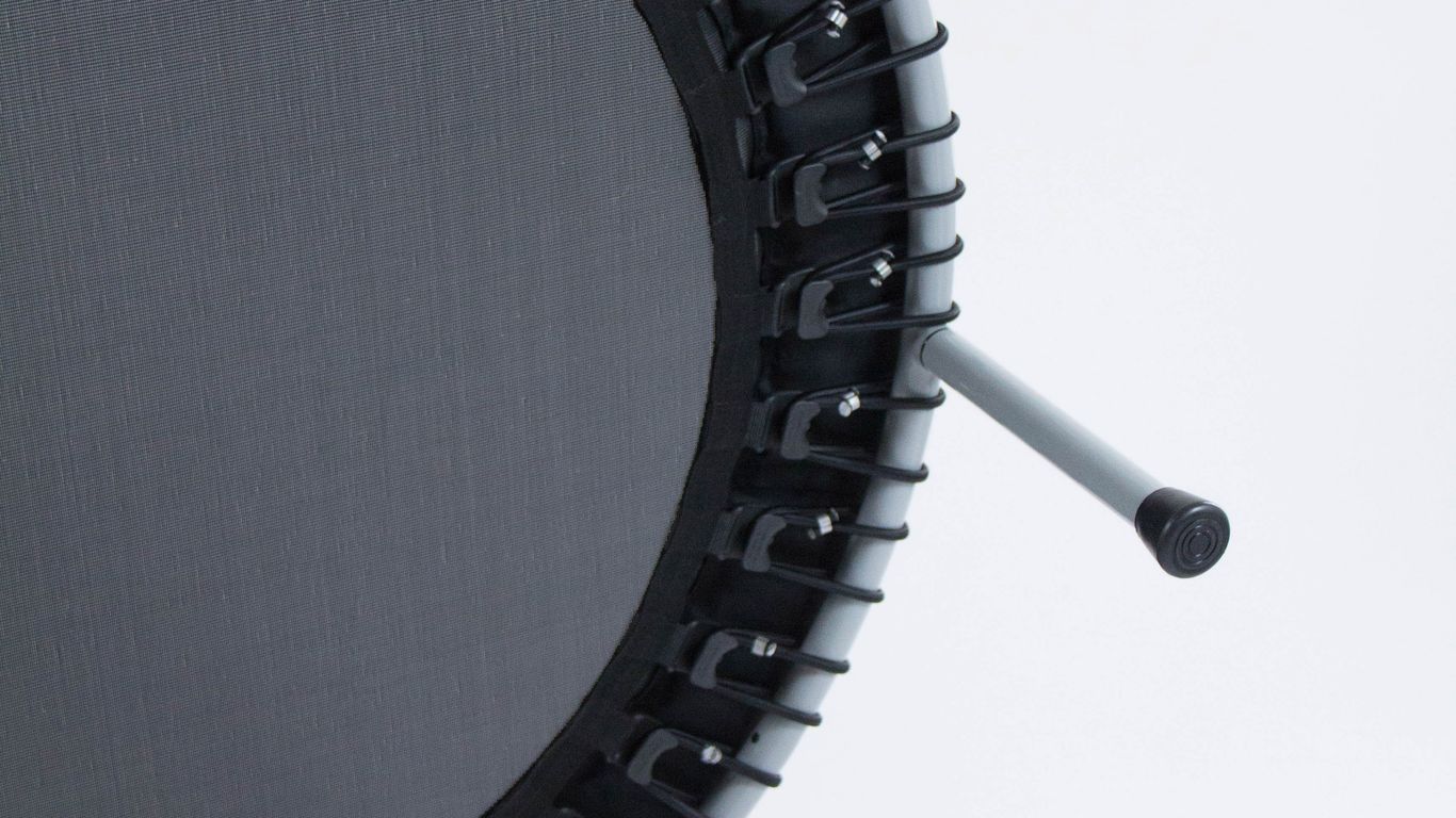 Close-up of a mini trampoline with black mat and legs.