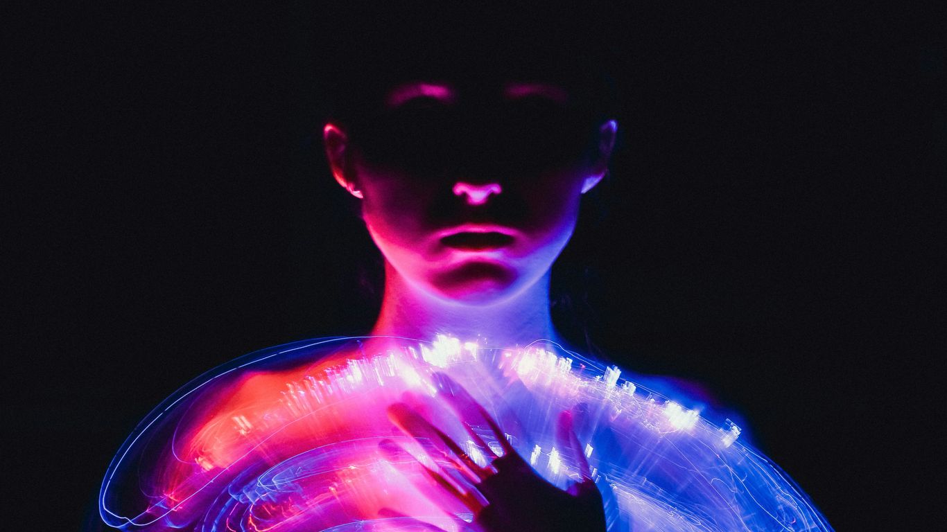 A woman in a white dress with neon lights on her body