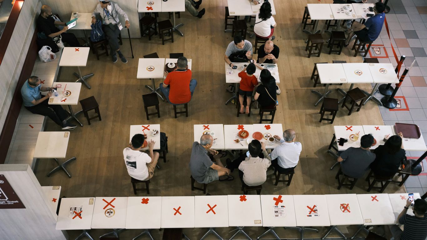 people in a room with white tables and chairs