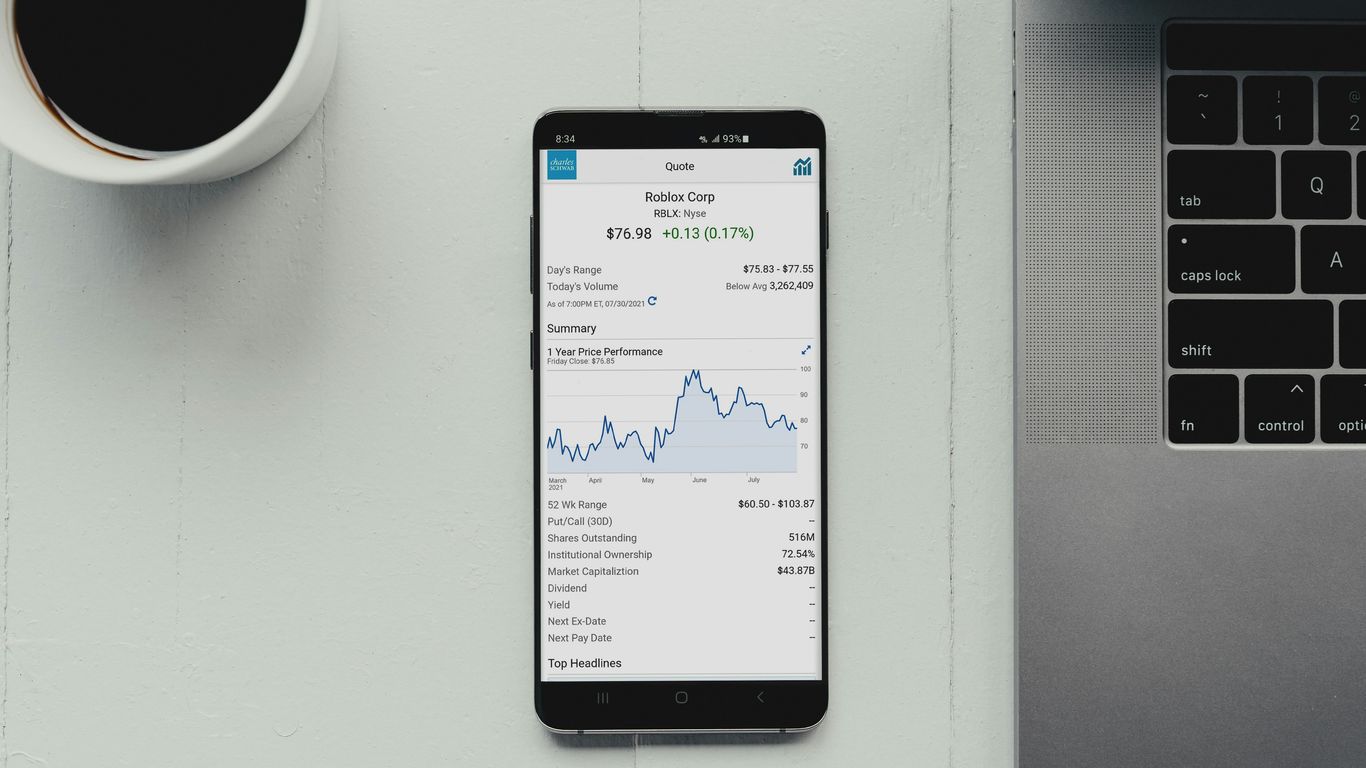 a cell phone sitting on top of a desk next to a laptop