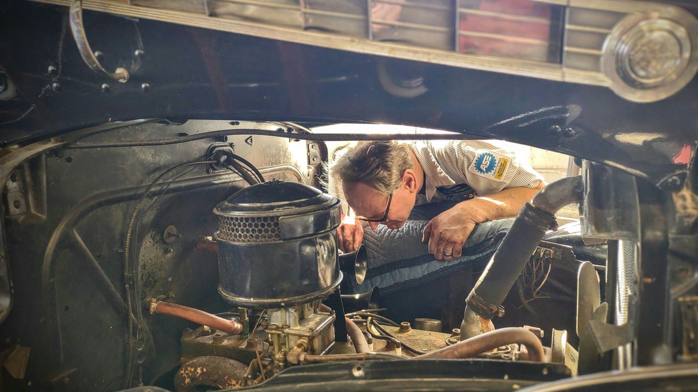a man working on a car engine in a garage