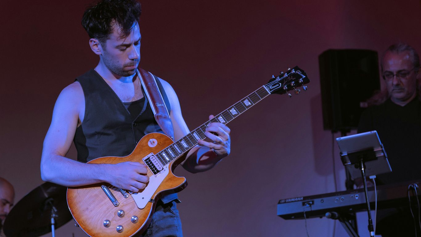 A man is playing a guitar on stage