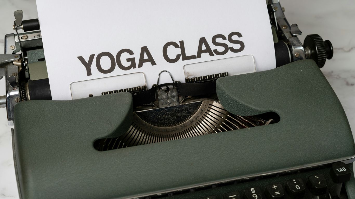a close up of a typewriter with a yoga class sign on it