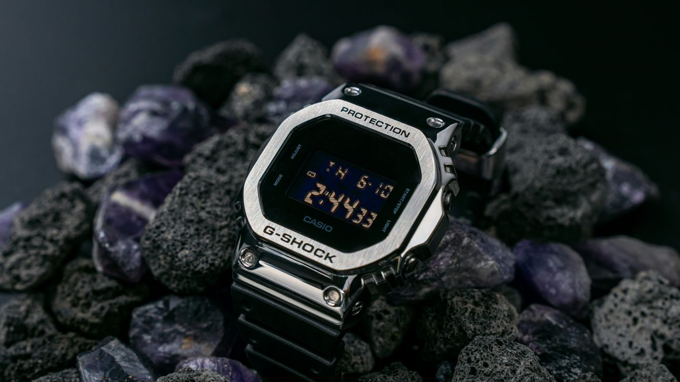 a digital watch sitting on top of a pile of rocks