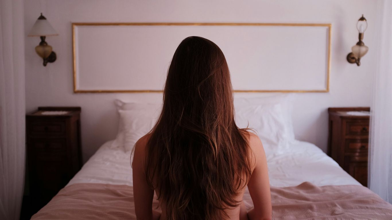 topless woman sitting on bed