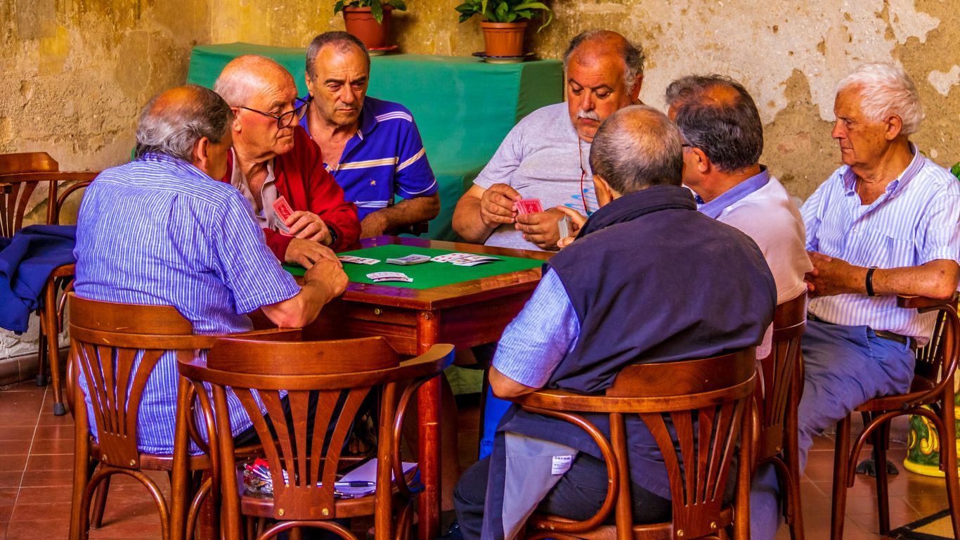 group of men sitting on chair in front of table