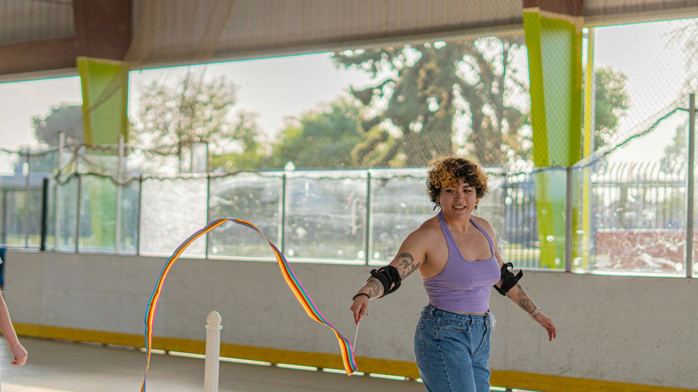 A woman skates with a ribbon.
