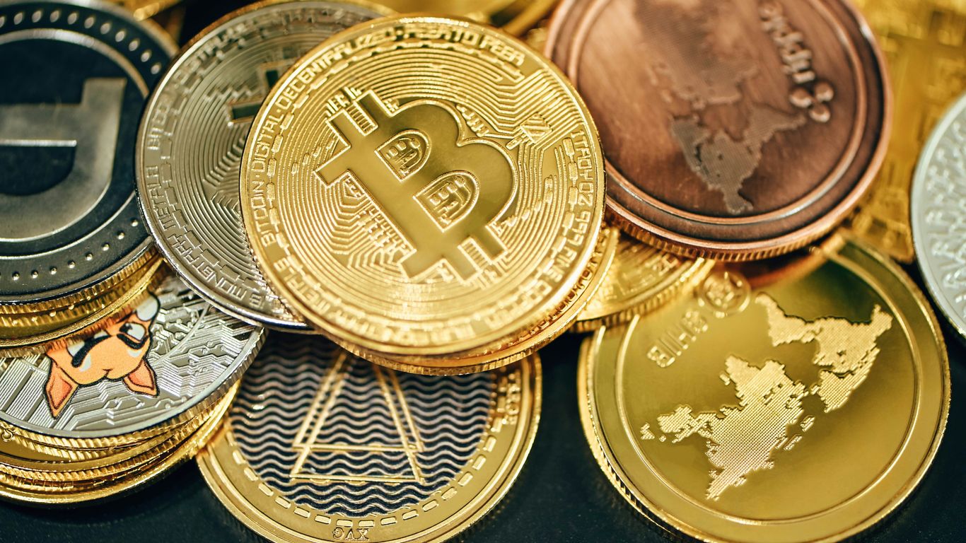 Various cryptocurrency coins displayed together on a surface.