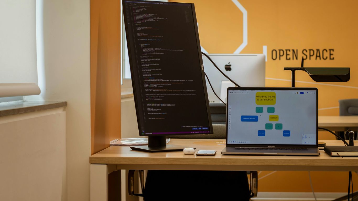 a laptop computer sitting on top of a wooden desk