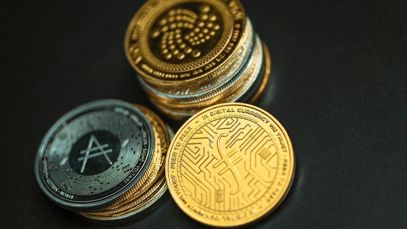 Stacks of cryptocurrency coins on a dark background.